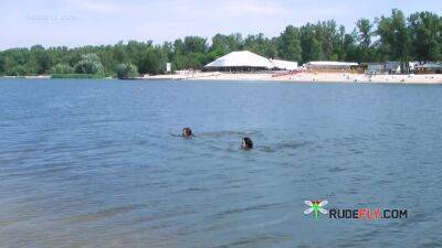 Nude beach girl sunbathes next to her man outdoors - hclips.com