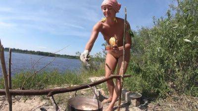 Girl Cooks Porridge On A Campfire - upornia.com