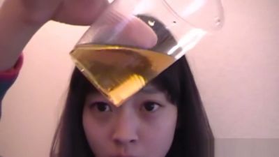 Young Asian performer sips golden fluid in intimate bathroom session - yesvids.com
