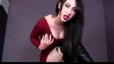 Confident woman in red dress gives herself a facial in a dark studio - yesvids.com