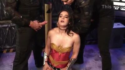 Wonder Woman subdued by two captors in a gritty industrial dungeon - yesvids.com