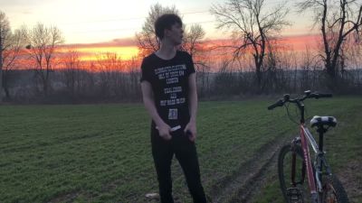 Young man with curly brown hair jerks off outdoors on a red bicycle during sunset - yesvids.com